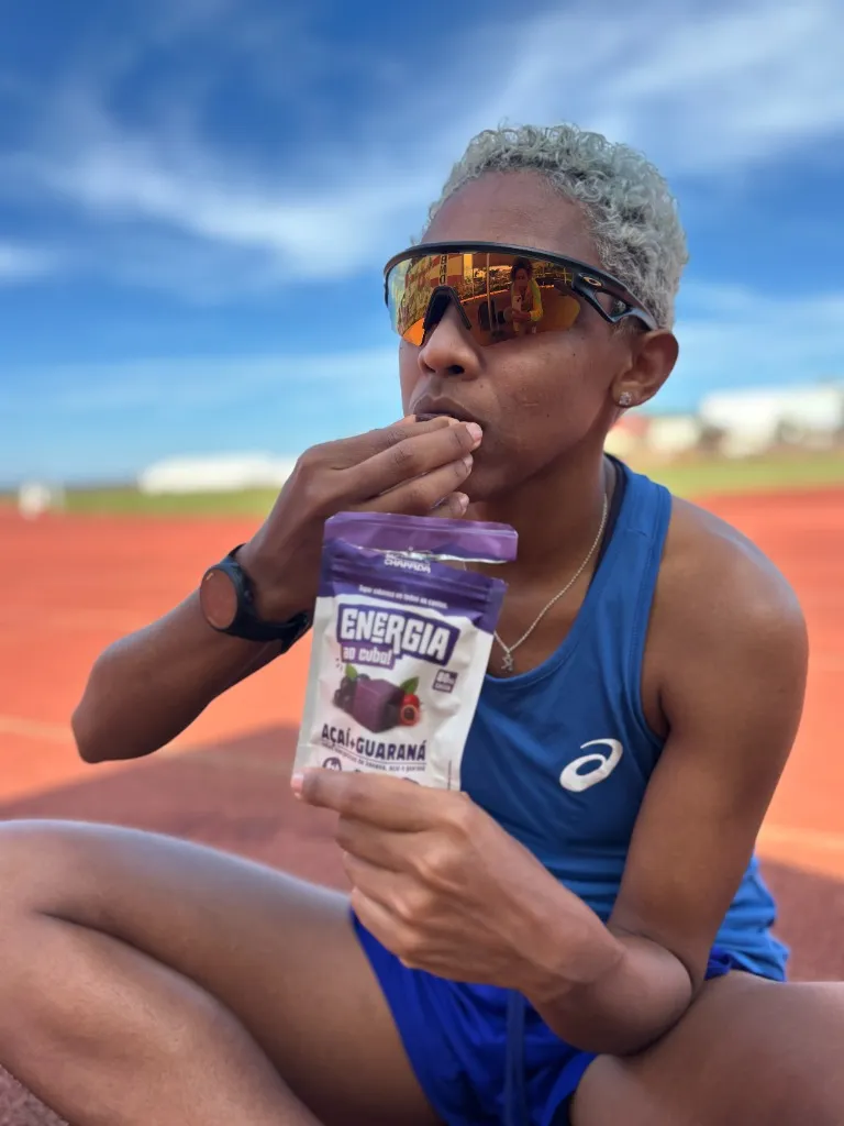 Keyla Barros atleta de alta performance comendo Cubinho Da Chapada na pista de atletismo